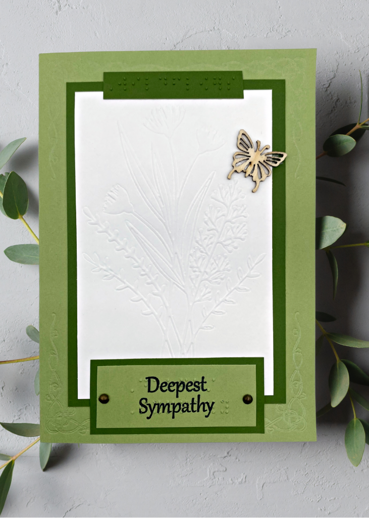 A calming green and cream card with embossed wildflowers that says Deepest Sympathy