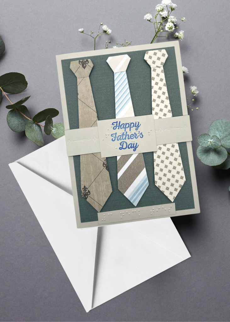 the father's day card sitting with a white envelope on a neutral grey backdrop
