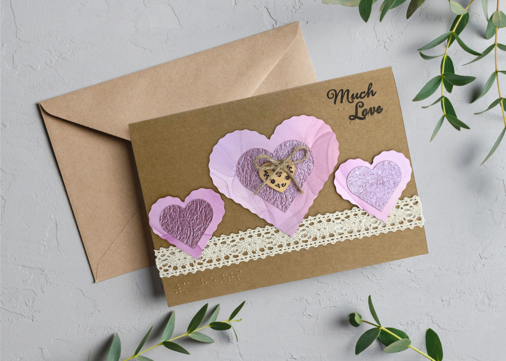 the much love card sitting with a brown envelope on a light brey backdrop