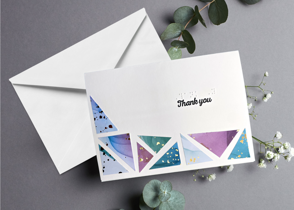 the thank you card with a white envelope on an neutral grey backdrop
