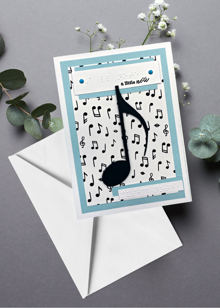 the music note card with a white envelope on a grey background
