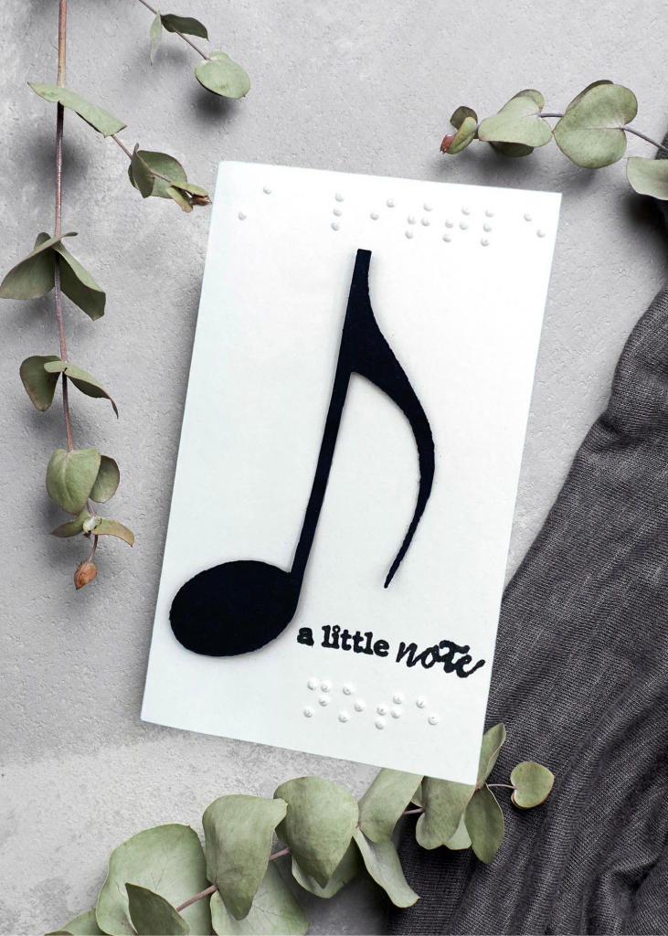 a cream card that says a little note with a musical eighth note on a neutral grey background