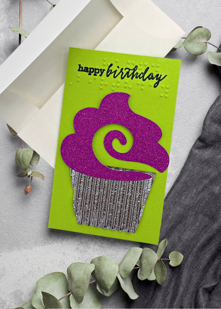 the happy birthday card with a white envelope on a neutral grey backdrop